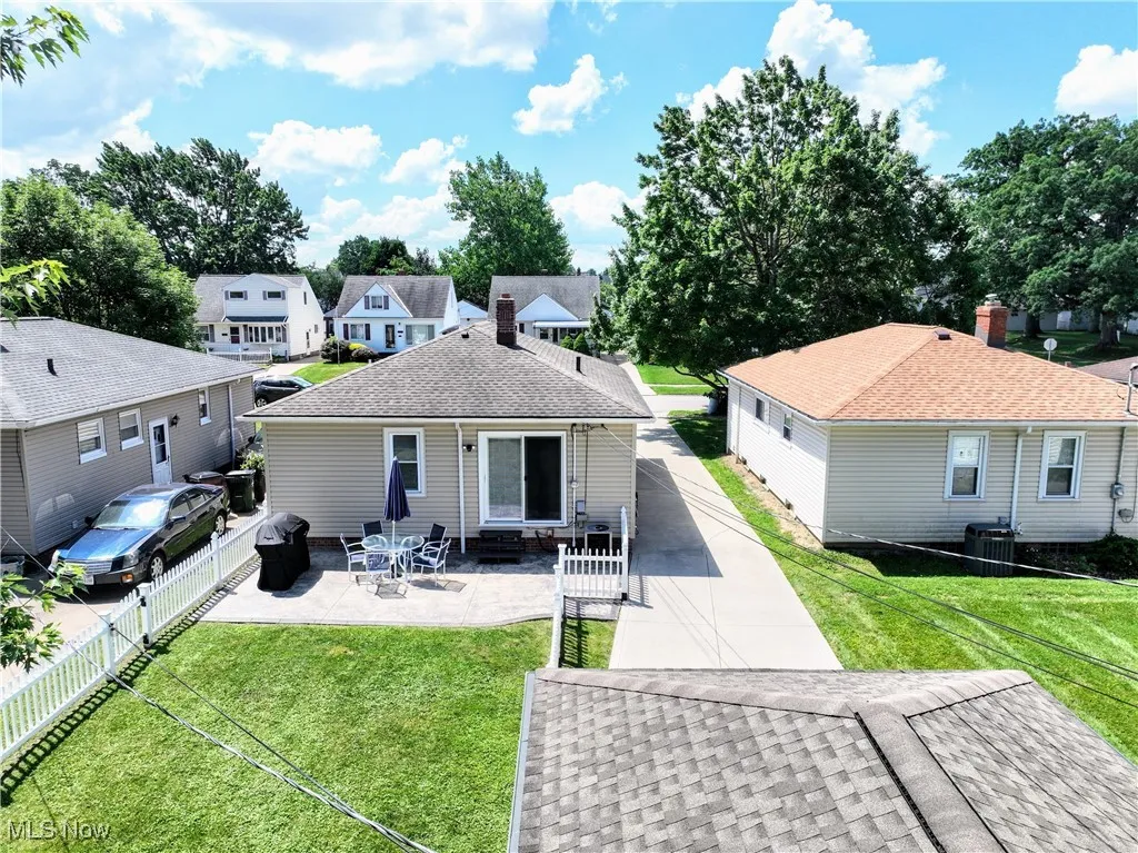 Back of house featuring a patio area, entry steps, a fenced backyard, a shingled roof, and a residential view