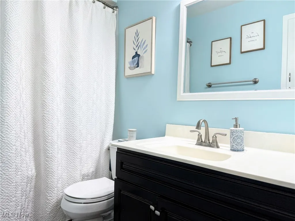 Full bath with vanity and a shower with curtain