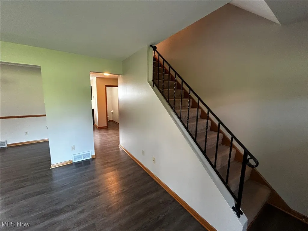 Stairway featuring wood finished floors and baseboards