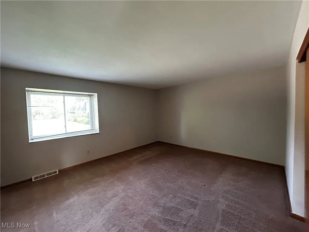 Spare room featuring carpet floors and baseboards