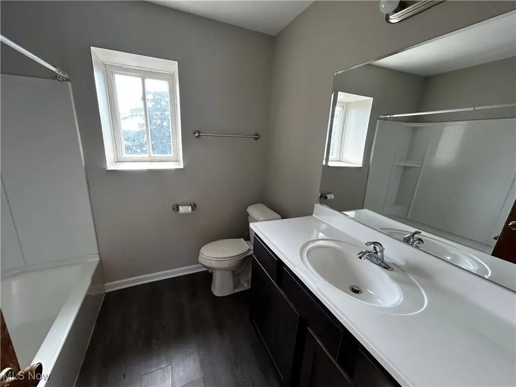 Bathroom featuring vanity, wood finished floors, and tub / shower combination