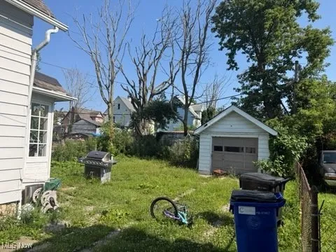 View of green lawn with a garage and an outdoor structure