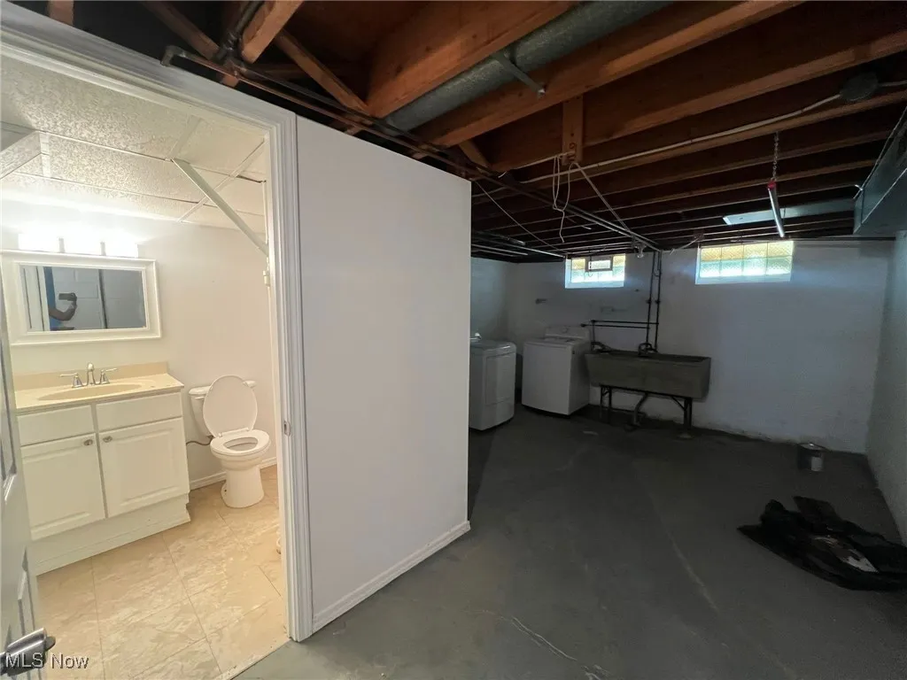 Below grade area with a sink and washing machine and clothes dryer