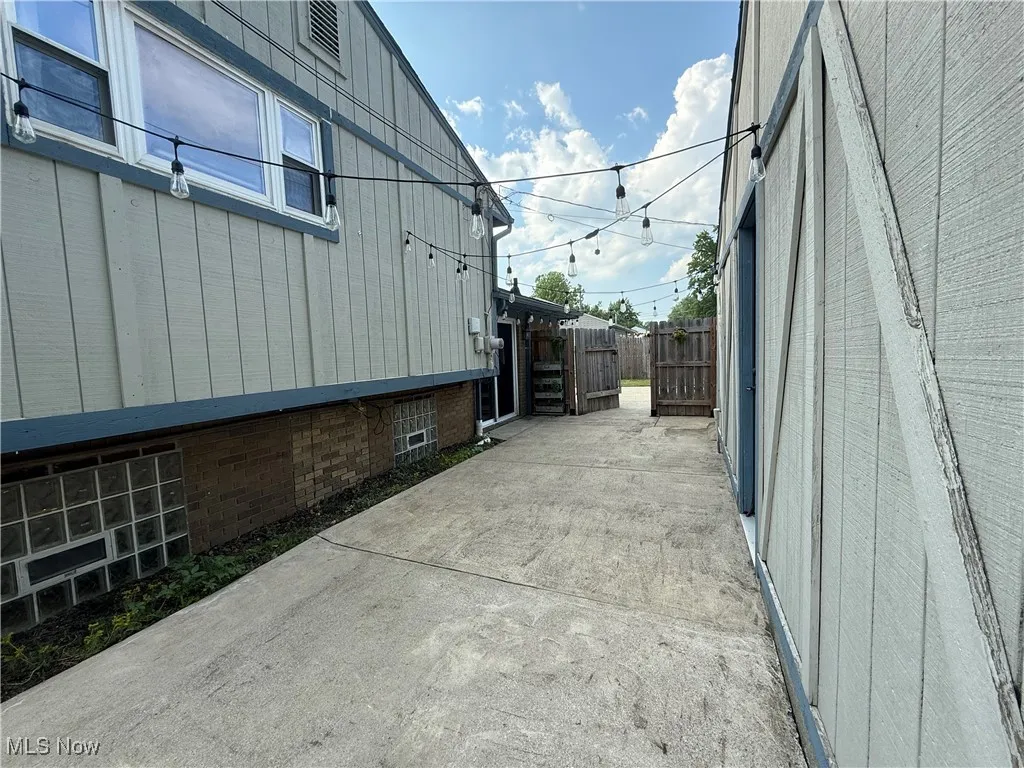 View of property exterior with a patio area and board and batten siding