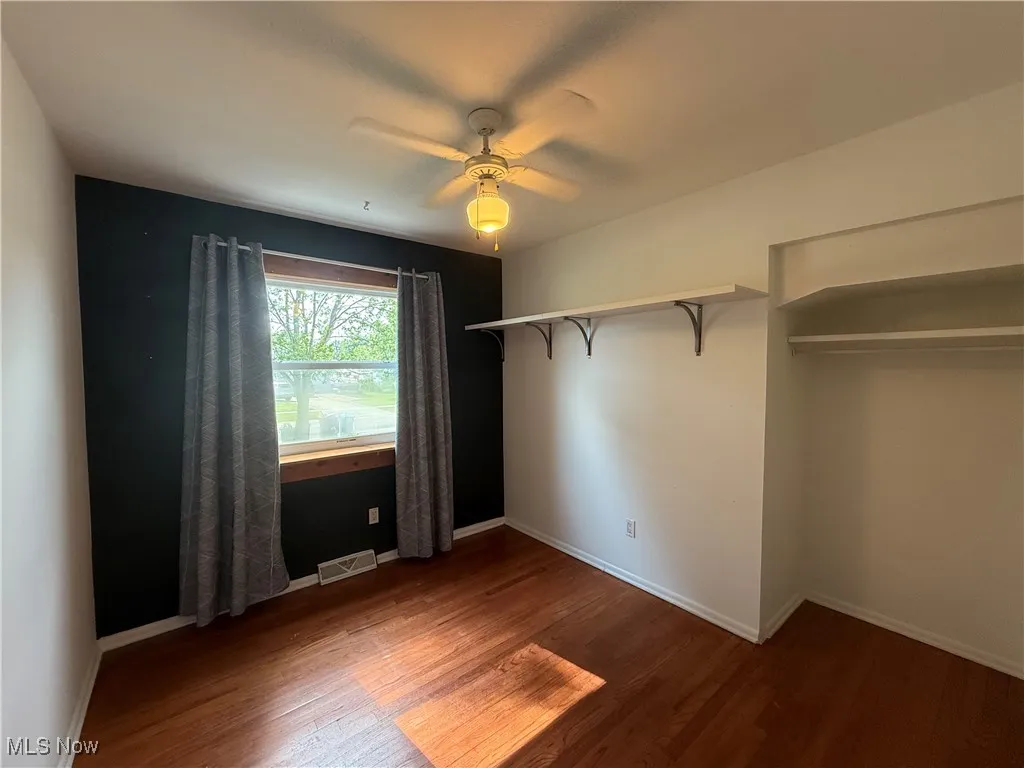 Unfurnished bedroom with wood finished floors and a ceiling fan
