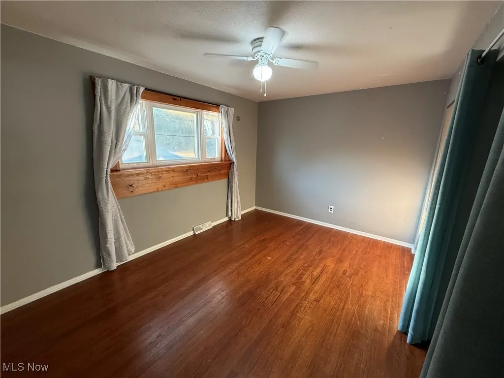 Spare room featuring wood finished floors and ceiling fan