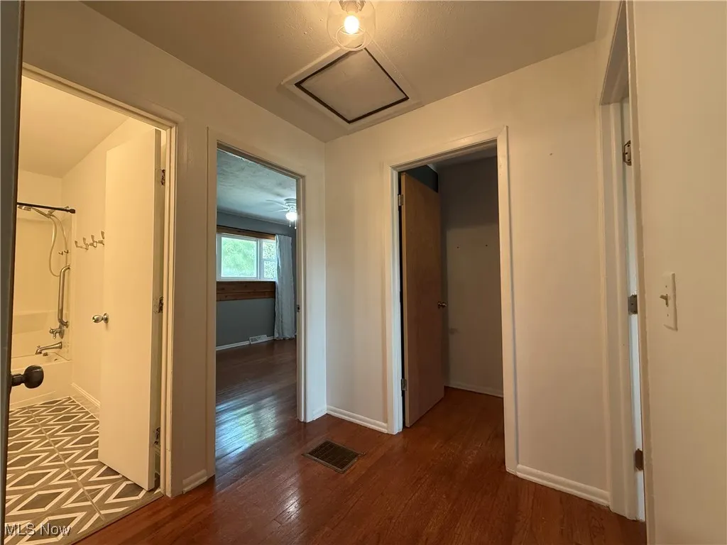 Hallway featuring dark wood finished floors and baseboards