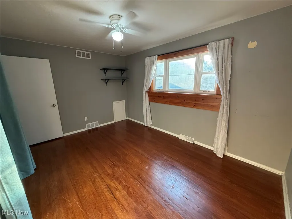 Unfurnished room with wood finished floors and ceiling fan