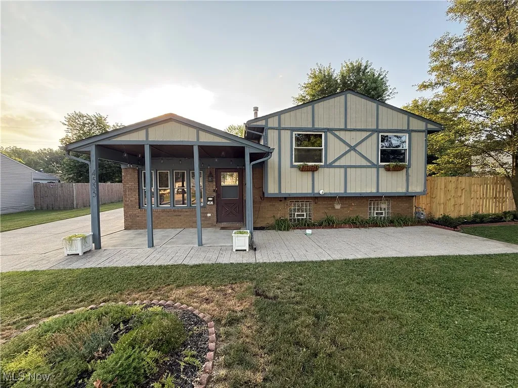Back of property with a patio and brick siding