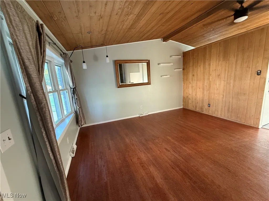 Spare room with wood ceiling, wood finished floors, and wood walls
