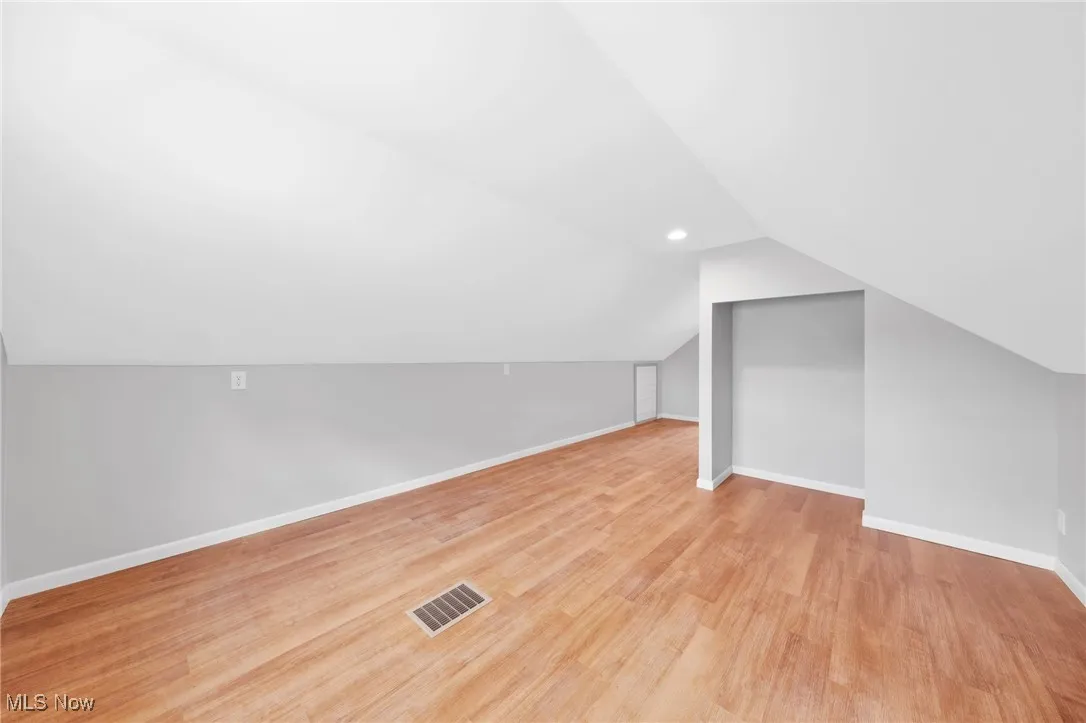 Bonus room with vaulted ceiling, light wood finished floors, and recessed lighting