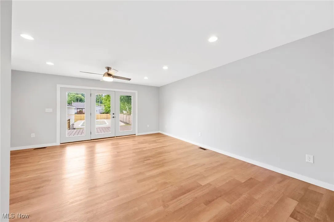 Empty room with recessed lighting, light wood-style floors, ceiling fan, and french doors