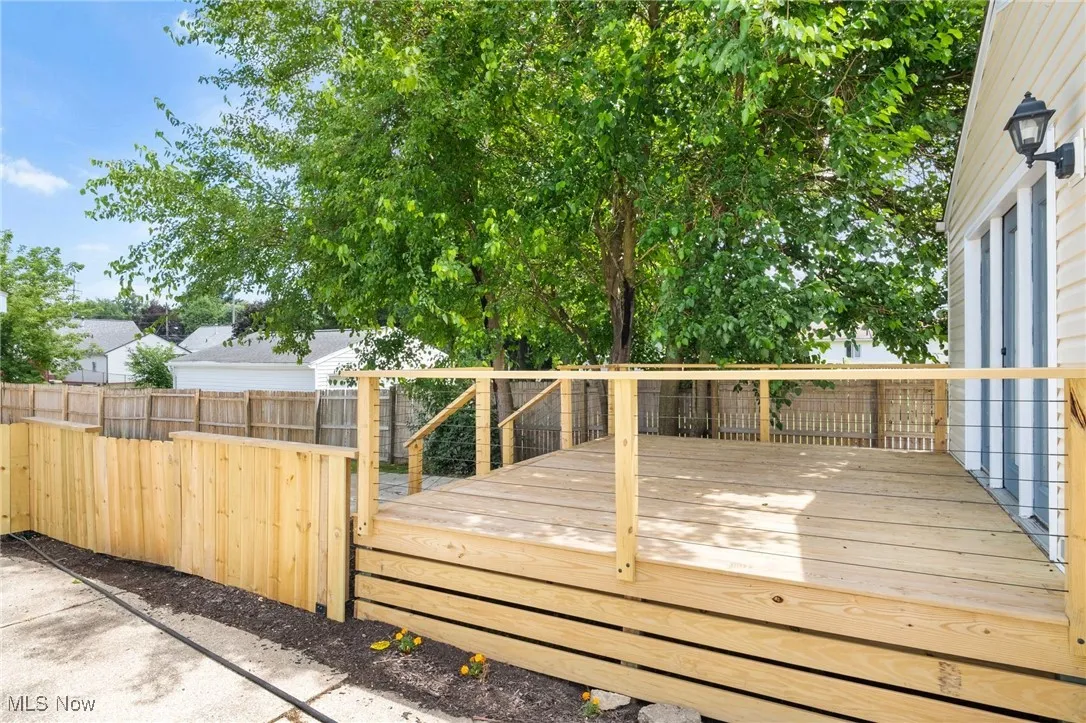 Wooden deck with a fenced backyard