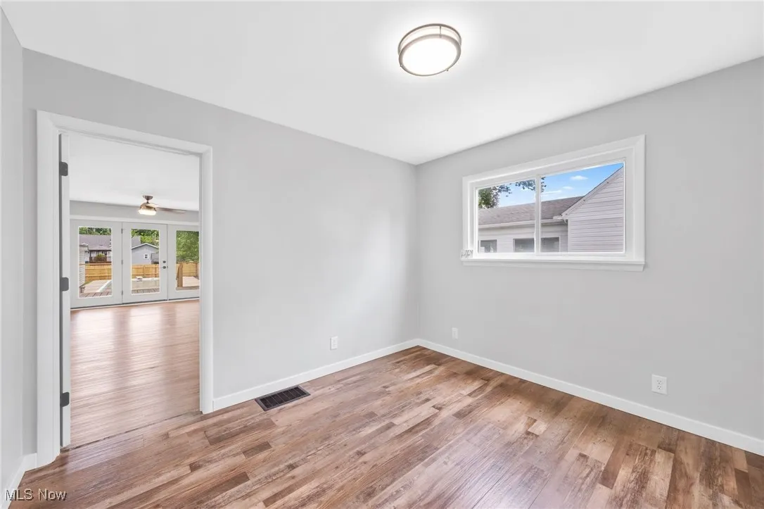 Unfurnished room with wood finished floors and french doors
