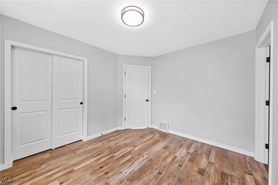 Unfurnished bedroom with light wood finished floors and a closet