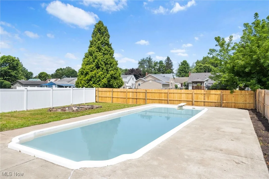 View of swimming pool with a patio, a fenced backyard, and a residential view