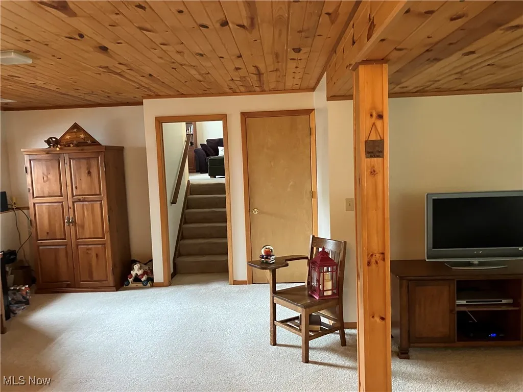 Sitting room featuring wood ceiling, carpet flooring, and stairway