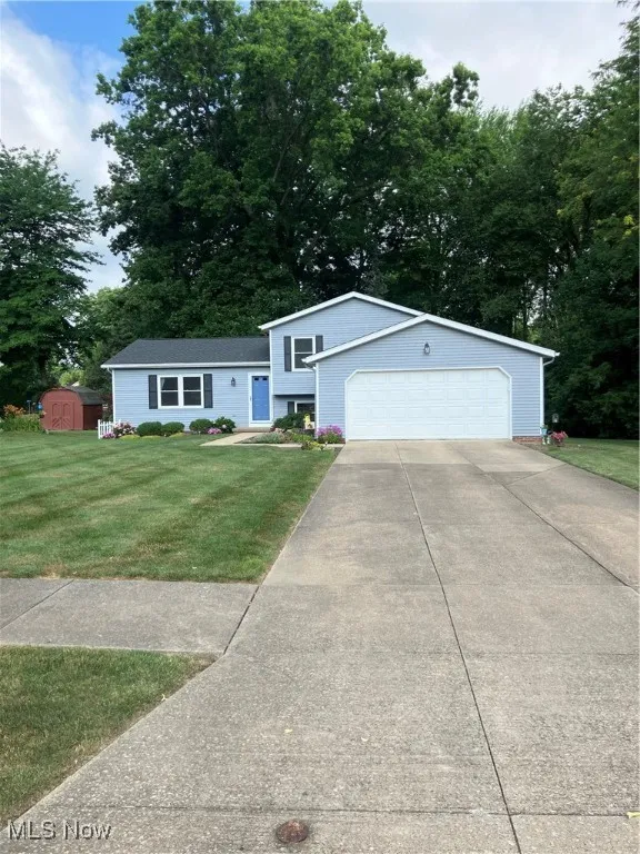 Split level home with a shed, a front lawn, and driveway