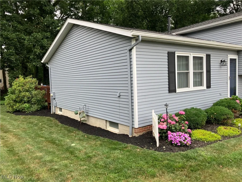 View of side of home featuring a yard
