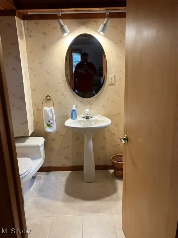 Half bath featuring toilet and tile patterned flooring