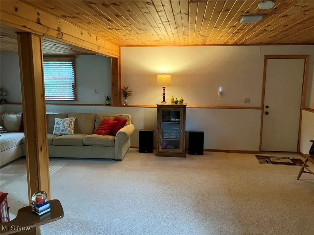 Carpeted living room featuring wood ceiling