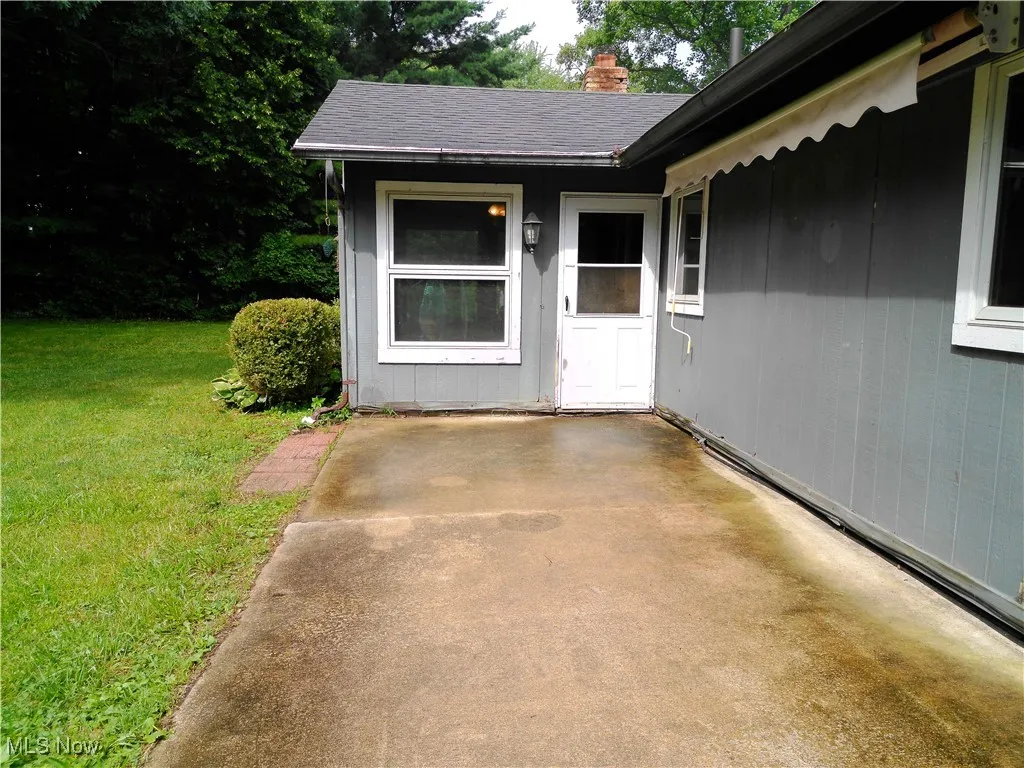 Property entrance featuring a lawn and a chimney