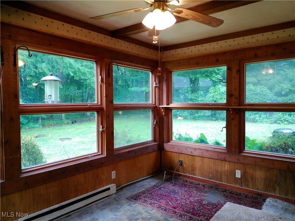 Unfurnished sunroom with a baseboard heating unit