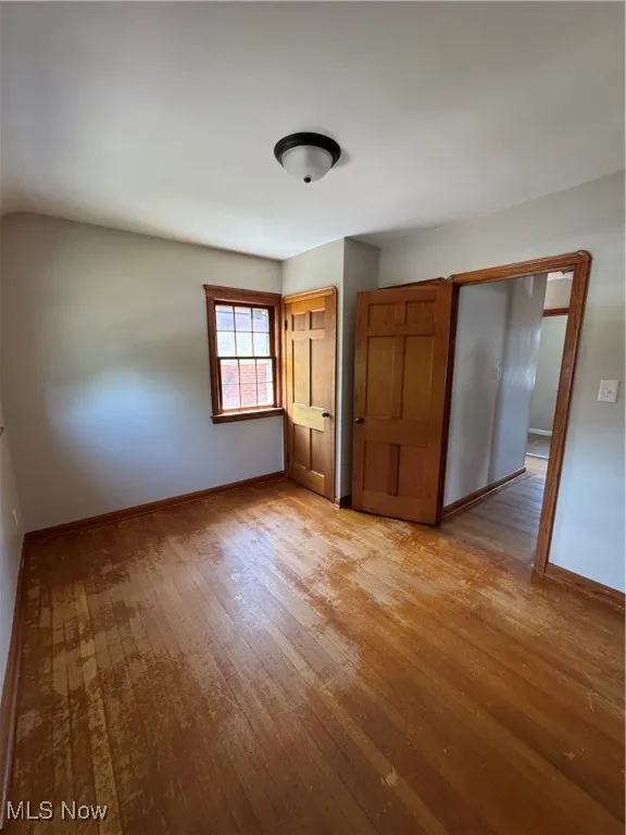 Bedroom 3 with light wood-style flooring and baseboards