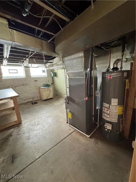 Below grade area featuring water heater and heating unit