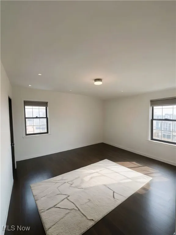 This picture is AI STAGED of bedroom 2 for imaginary purposes featuring healthy amount of natural light, dark wood-type flooring, and recessed lighting