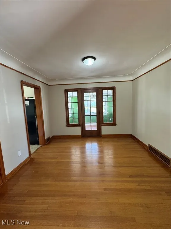 Unfurnished room featuring crown molding and light wood-style floors