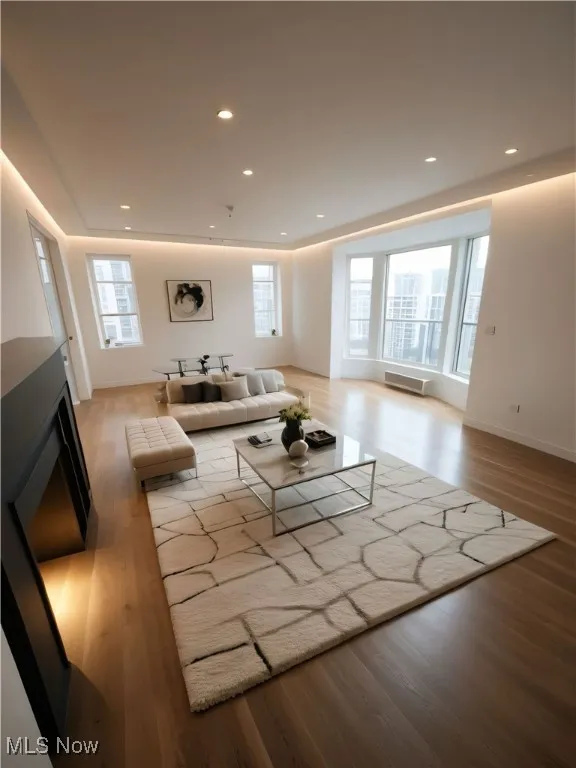 This picture is AI STAGED for imaginary purposes. Living area featuring wood finished floors and recessed lighting