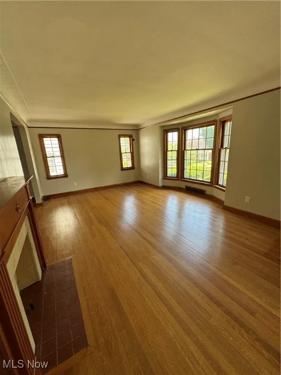 Spare room with dark wood finished floors and baseboards