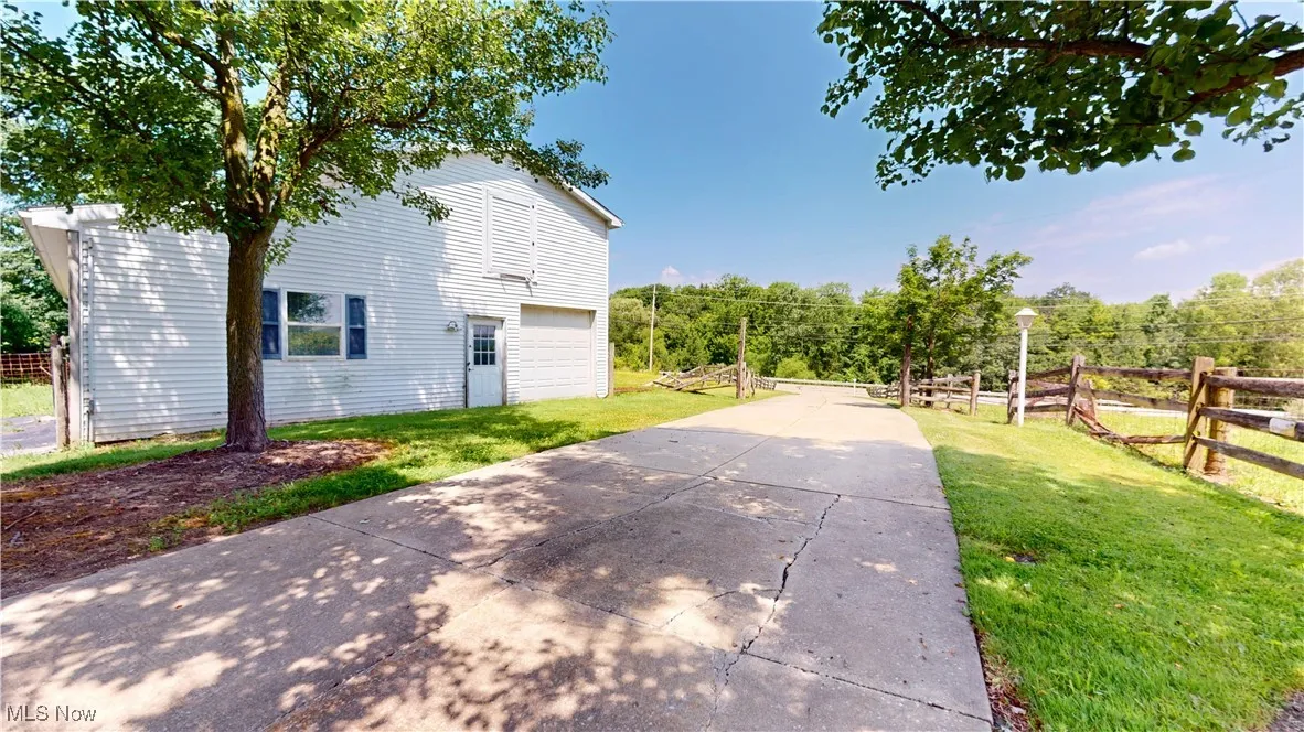 View of side of home featuring a garage and driveway
