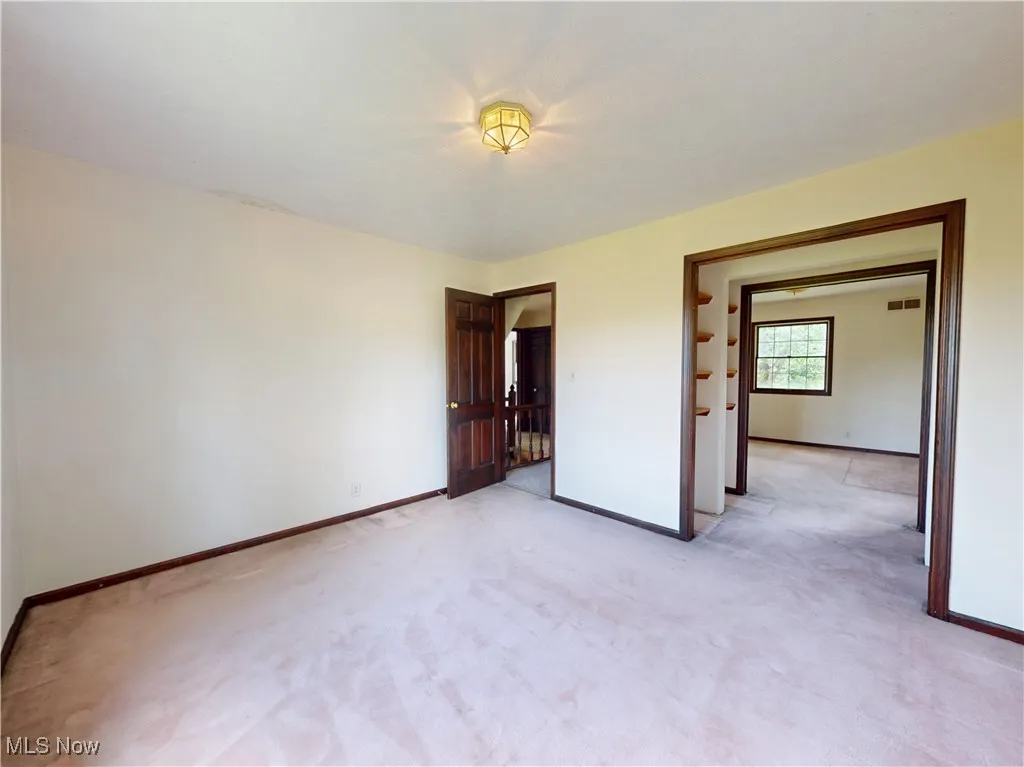 Unfurnished bedroom featuring baseboards and light colored carpet