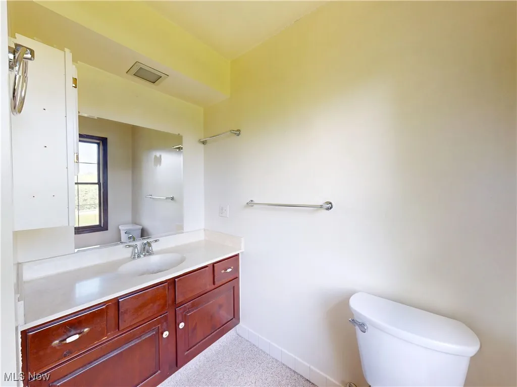 Half bathroom with toilet and vanity