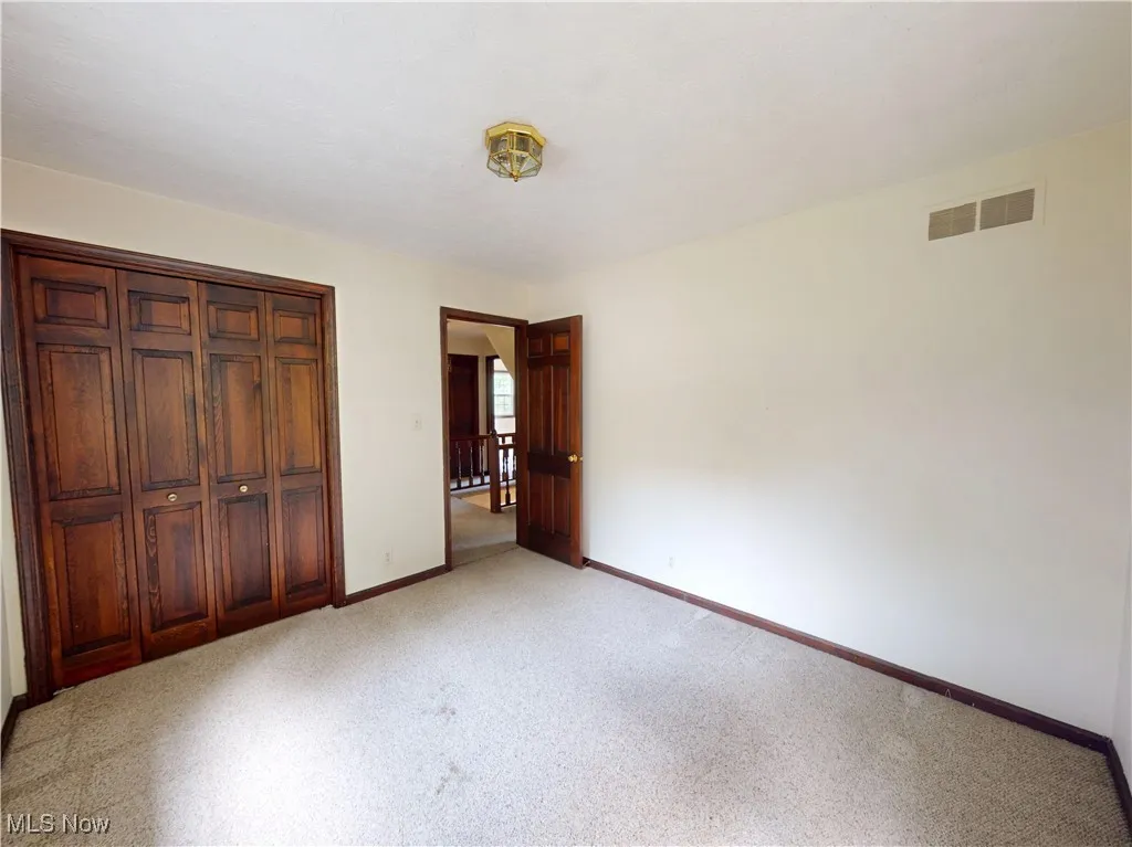 Unfurnished bedroom featuring light colored carpet and a closet