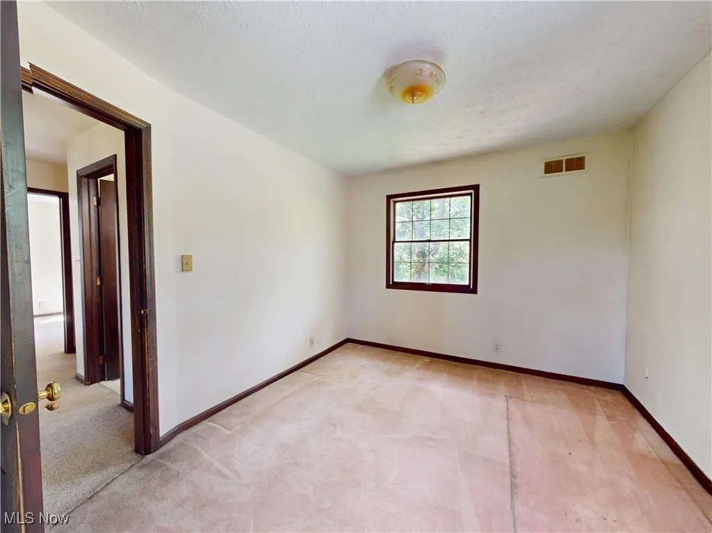 Empty room featuring light colored carpet
