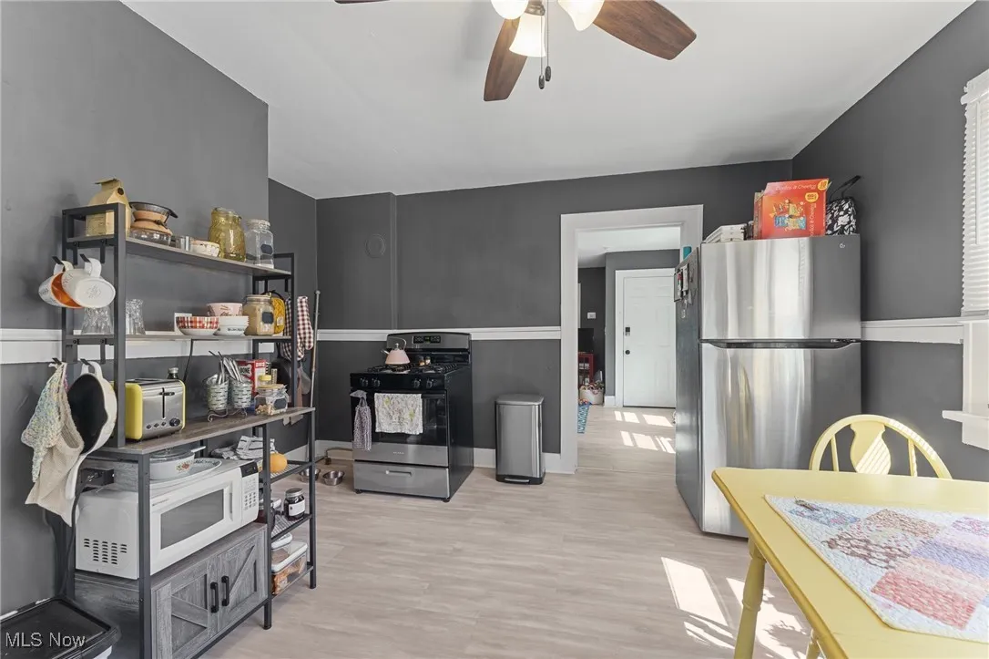 Kitchen with appliances with stainless steel finishes, ceiling fan, and light wood-style floors