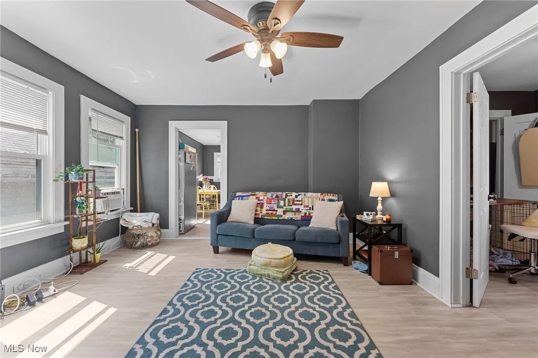 Living area featuring ceiling fan and light wood-style flooring