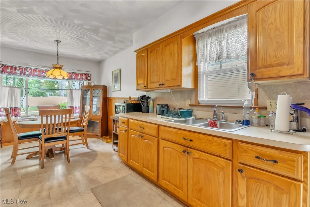 Kitchen with light countertops, tasteful backsplash, and stainless steel microwave