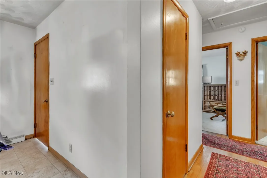 Hall featuring attic access and a baseboard radiator