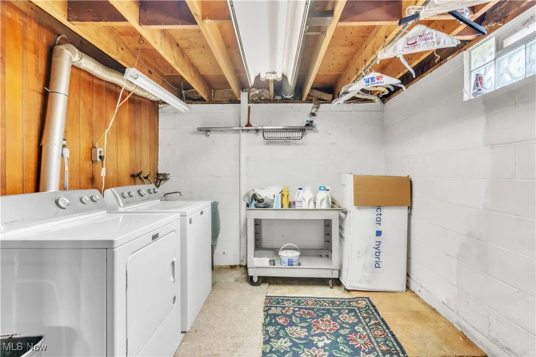 Washroom with independent washer and dryer and concrete block wall