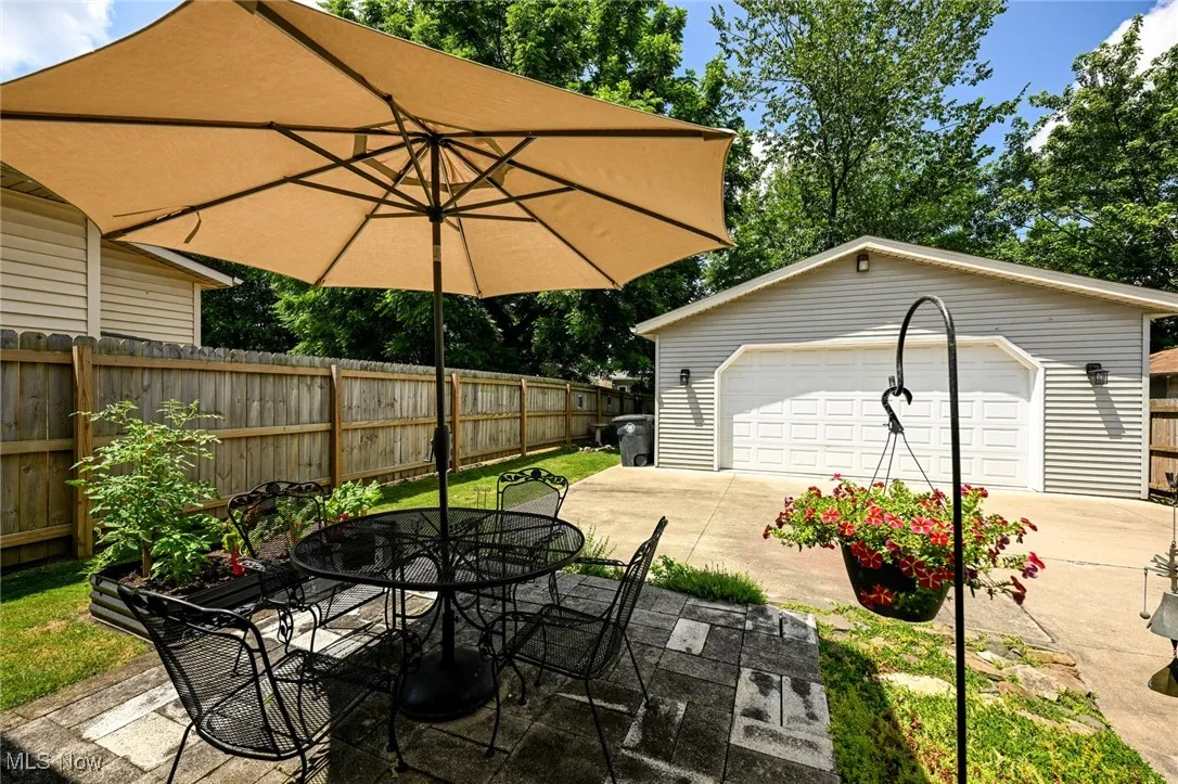 View of patio featuring a detached garage, an outbuilding, and outdoor dining space