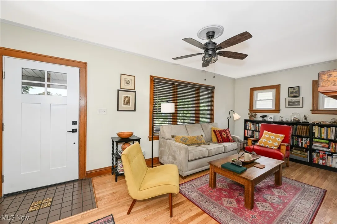 Living area with light wood-style flooring and a ceiling fan