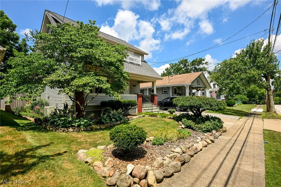 View of front of property featuring a front lawn and a shingled roof