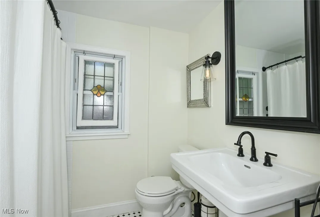Full bathroom featuring toilet and a shower with shower curtain