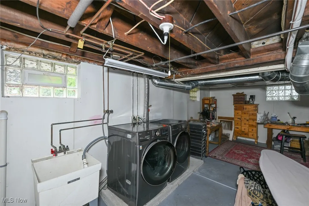 Basement featuring washer and clothes dryer and a sink