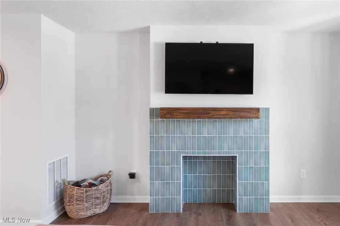 Detailed view of wood finished floors and a fireplace