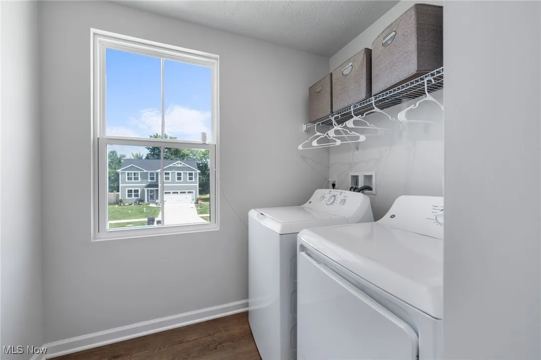 Laundry area with washer and dryer and dark wood finished floors